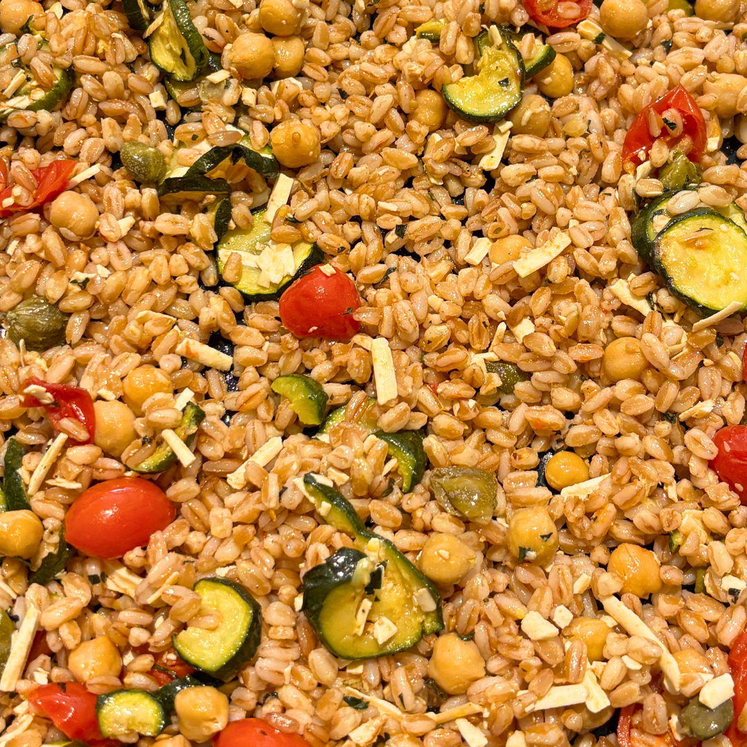 Insalata di farro con zucchine, pomodorini, ceci, capperi e scaglie di formaggio