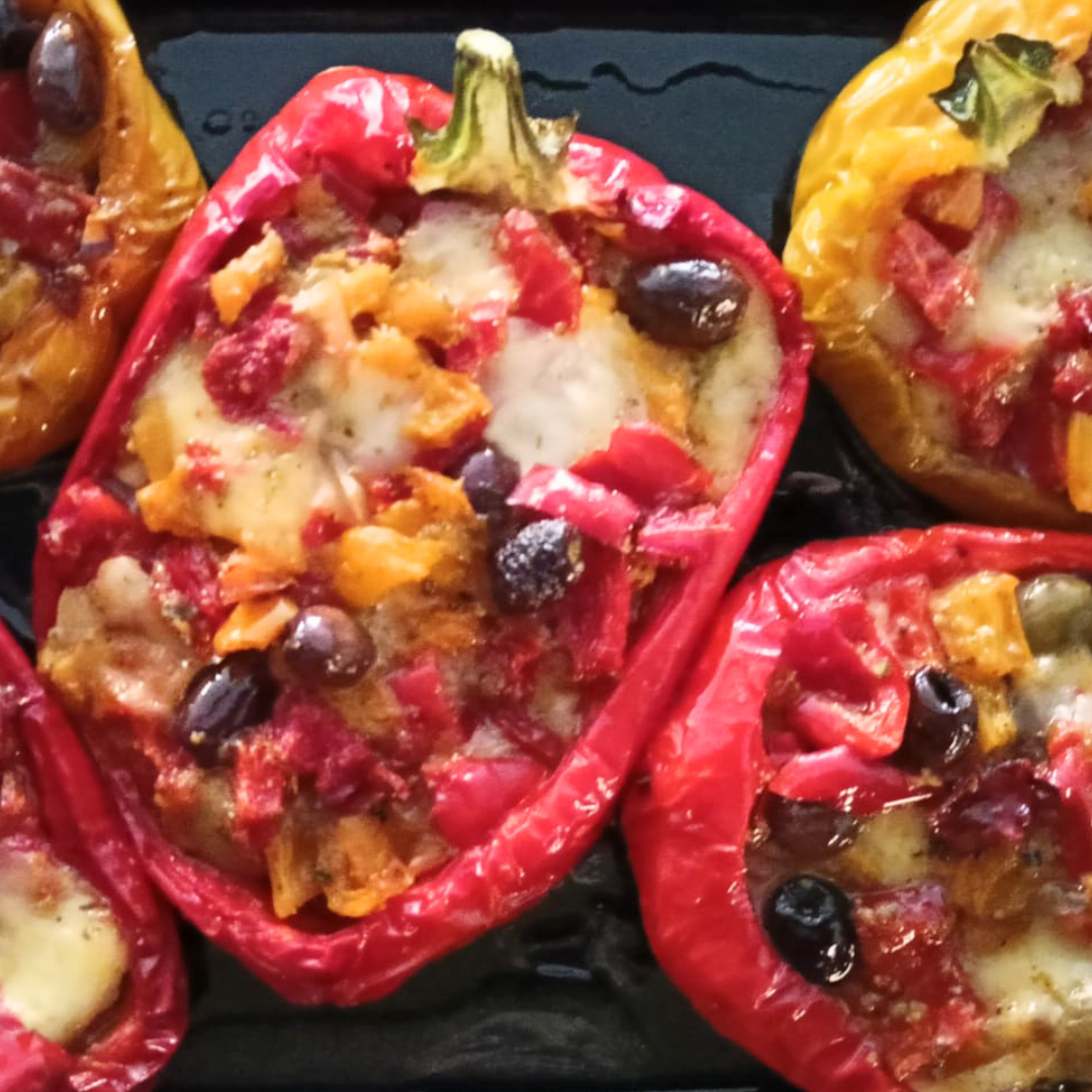 Peperoni rossi e gialli ripieni al forno con pomodoro, olive e formaggio fuso