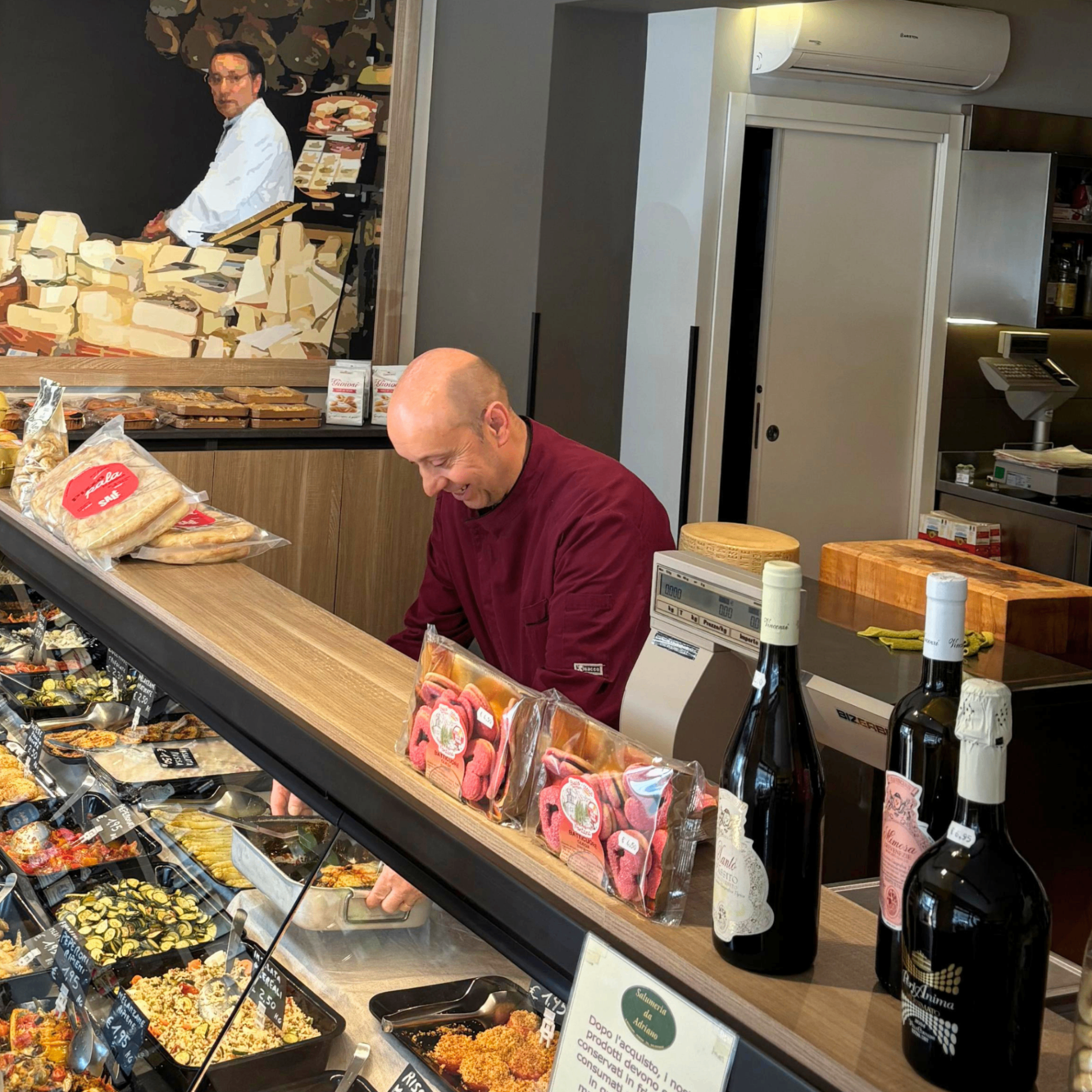 Roberto Rigo al lavoro in bottega, con la fotografia incorniciata del padre Adriano alle spalle